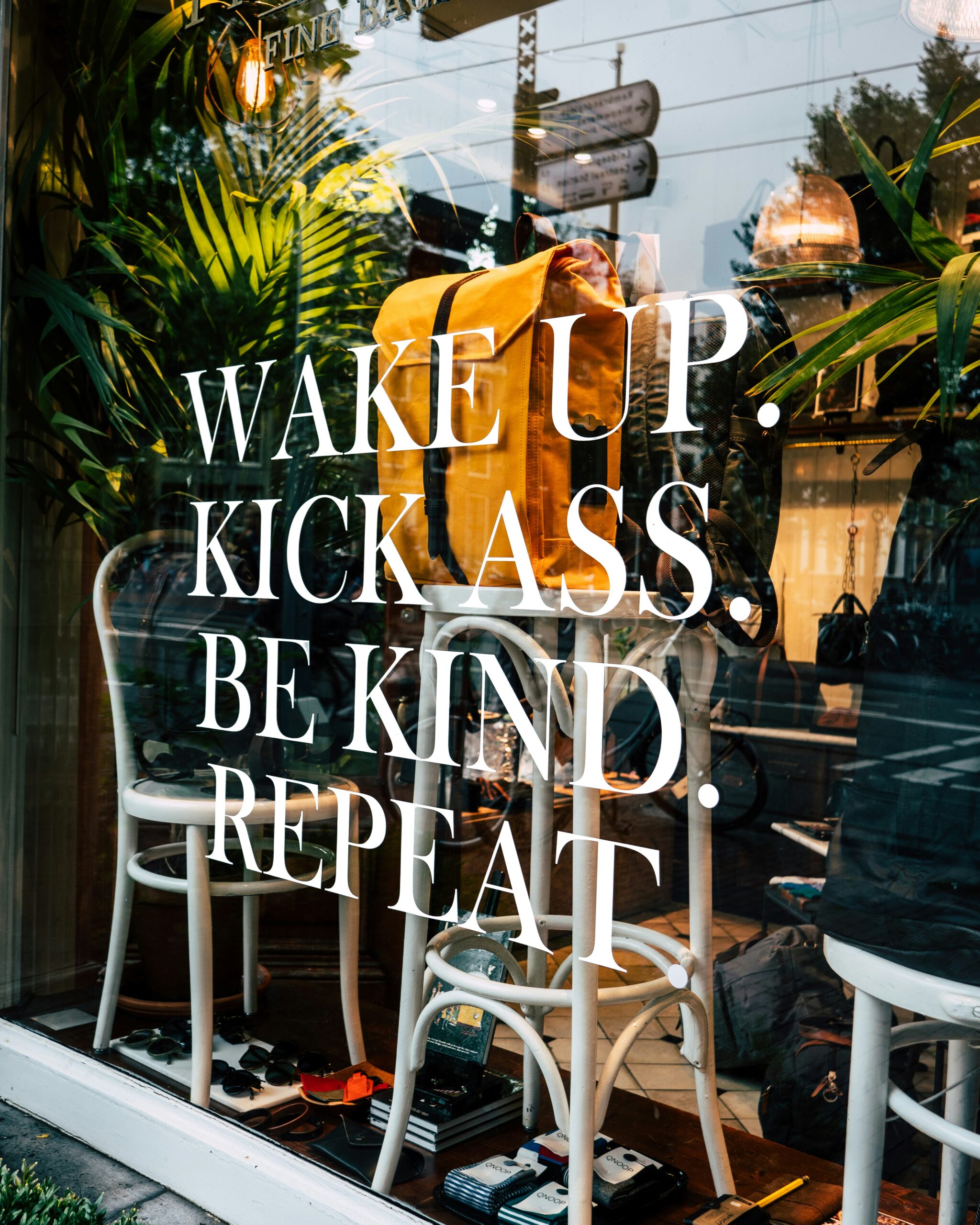 Shop window lettered Wake up. Kick ass. Be kind. Repeat.