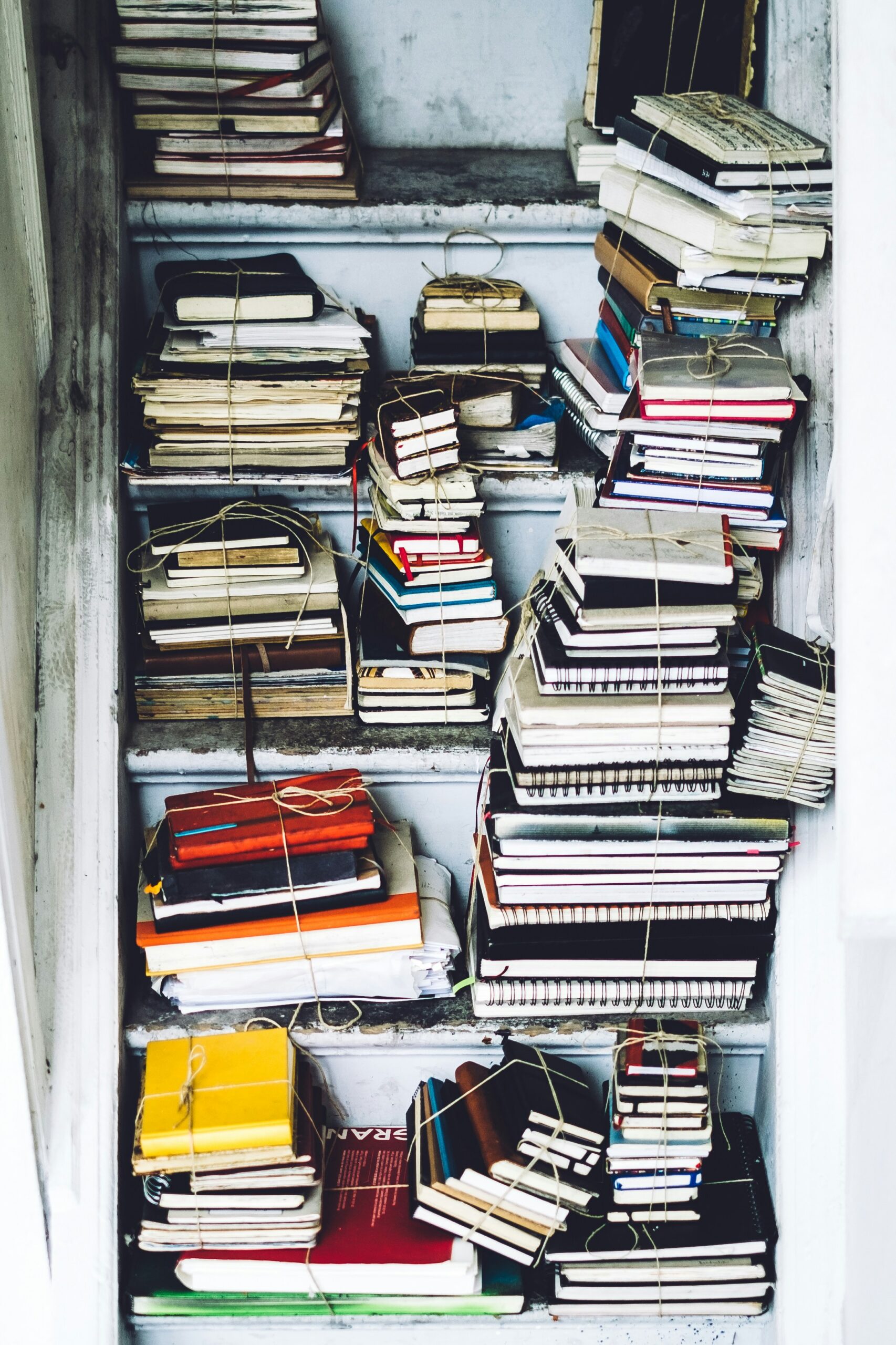 Stacks of bundled books and notebooks on a shelf