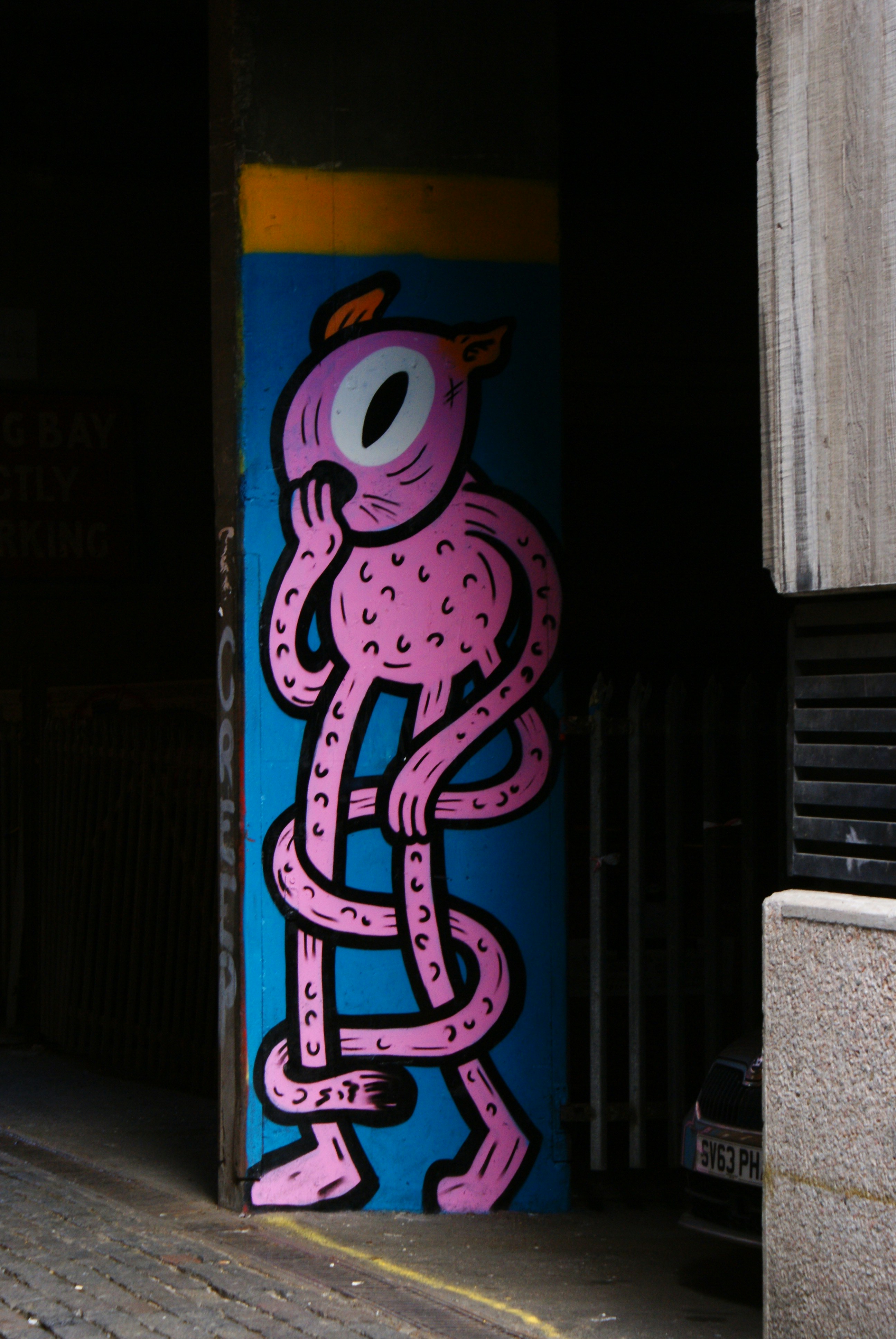 A pink tangled creature painted on a wall