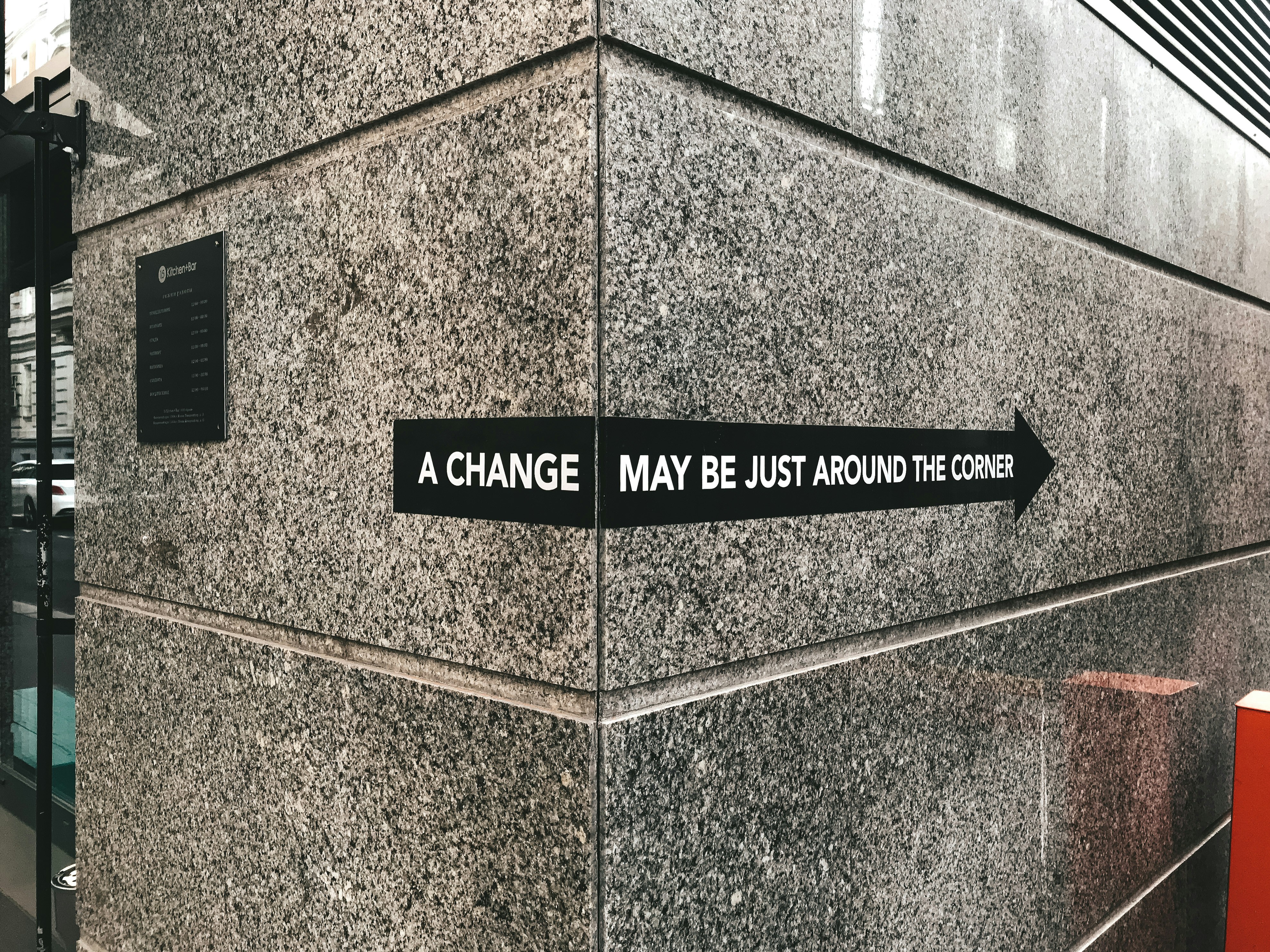 A change may be just around the corner, sign on a granite wall
